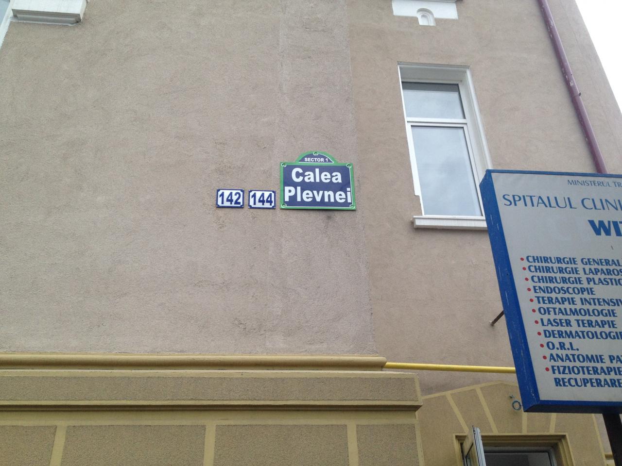 Зелена улична табела Calea Plevnei, Sector 1, с номера 142 и 144 върху фасада в Букурещ.